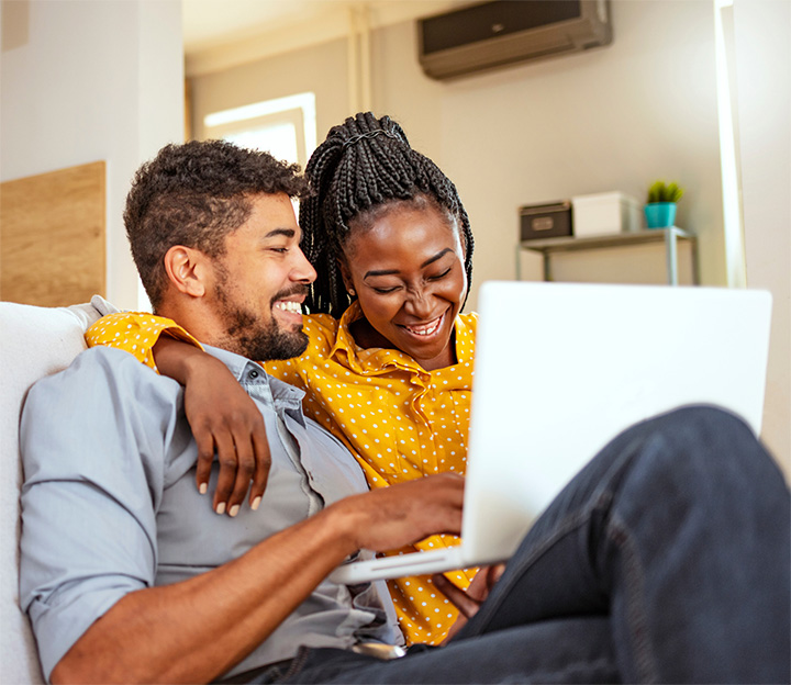 Un couple heureux utilise un ordinateur portable