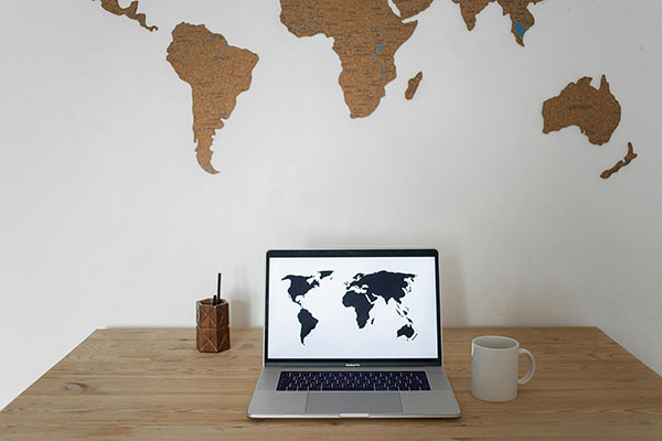 Ordinateur portable affichant une carte du monde, représentant nos services dans cinq pays